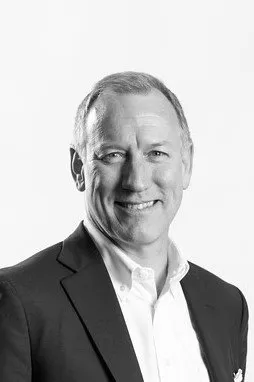 A man in a suit and tie smiling for the camera.